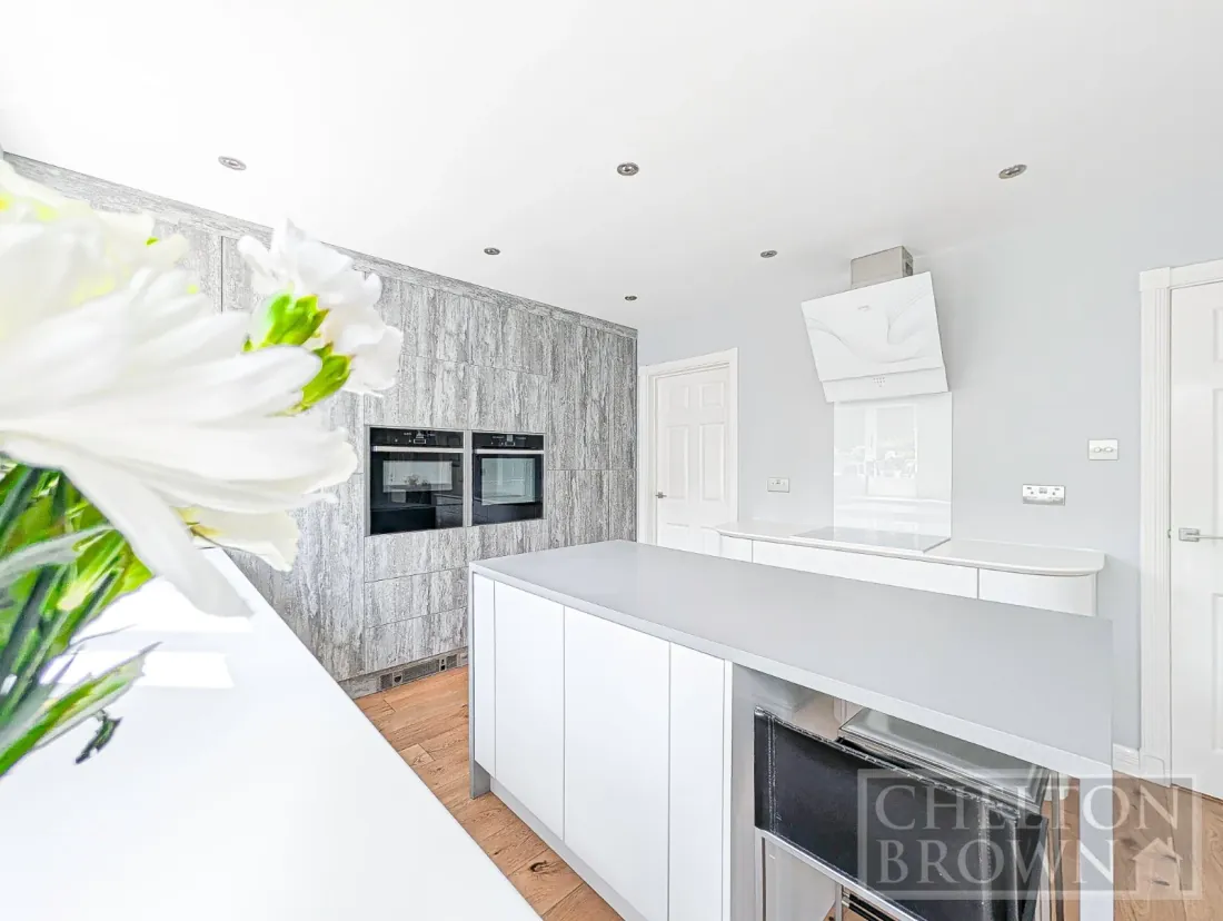 The kitchen at Bradbury Road, with twin Neff appliances and the wood-grain accent wall