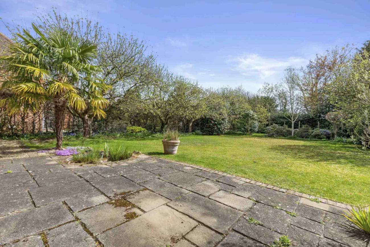 Wraparound terrace and lawn looking back at the home
