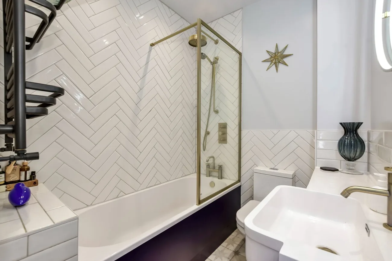 The family bathroom — herringbone tile shower screen