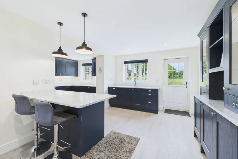 The kitchen peninsula and breakfast bar in deep navy and Minerva, looking through to the kitchen proper