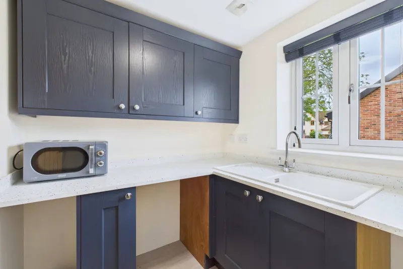 The utility room, fitted with matching navy cabinetry and Minerva worktops