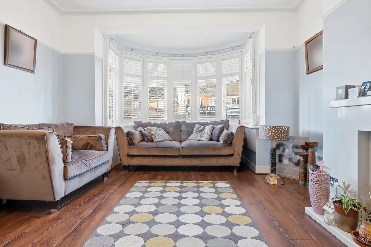 Living room — bay window with twin sofas and warm wood floor