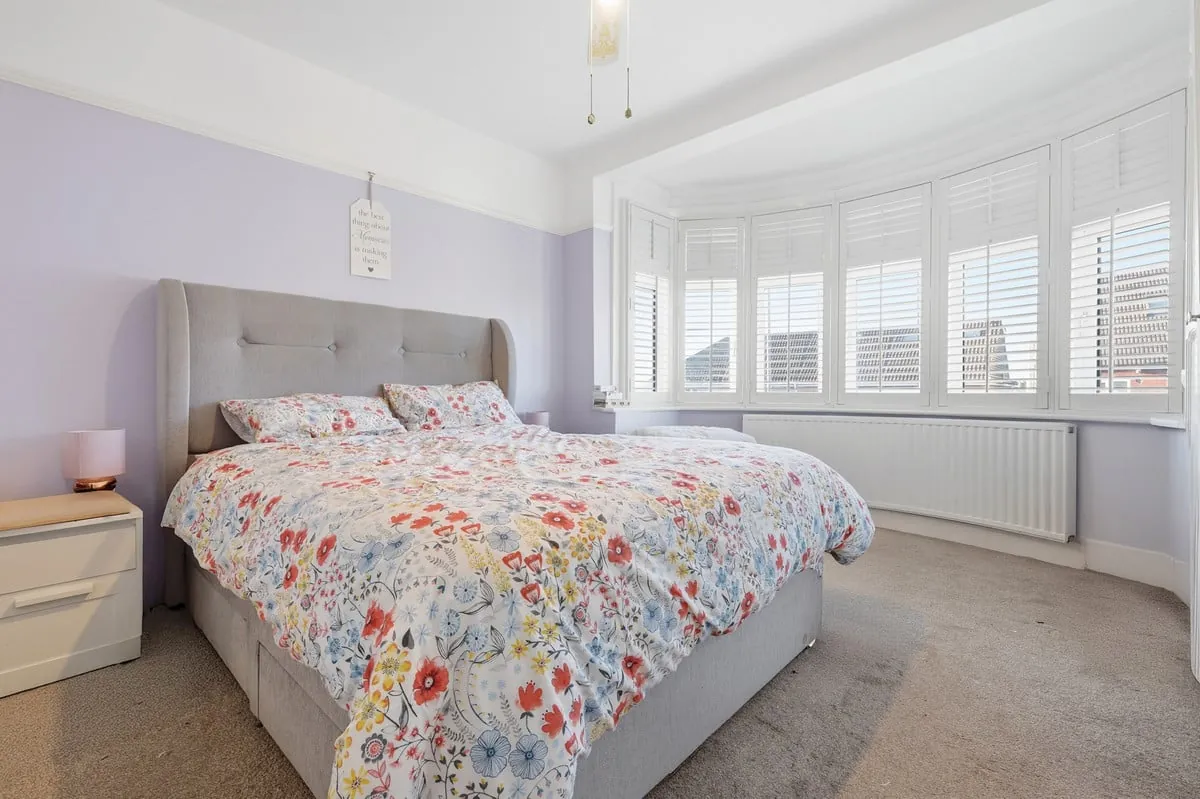 Second bedroom — bay window and soft pink accents