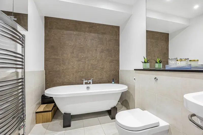 The family bathroom — claw-foot bath against panelled walls