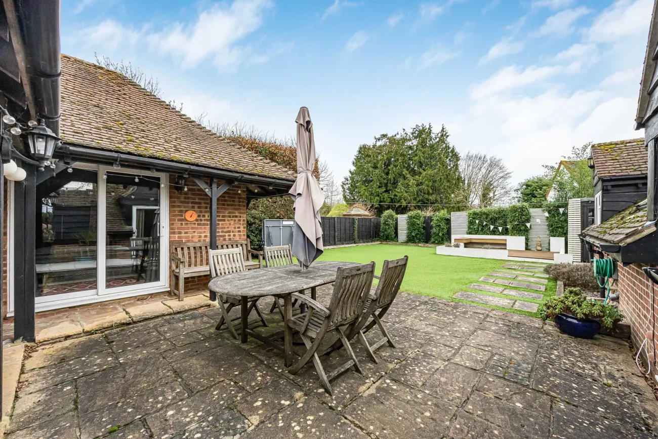 The garden behind the home — formal lawn and a chair on the patio