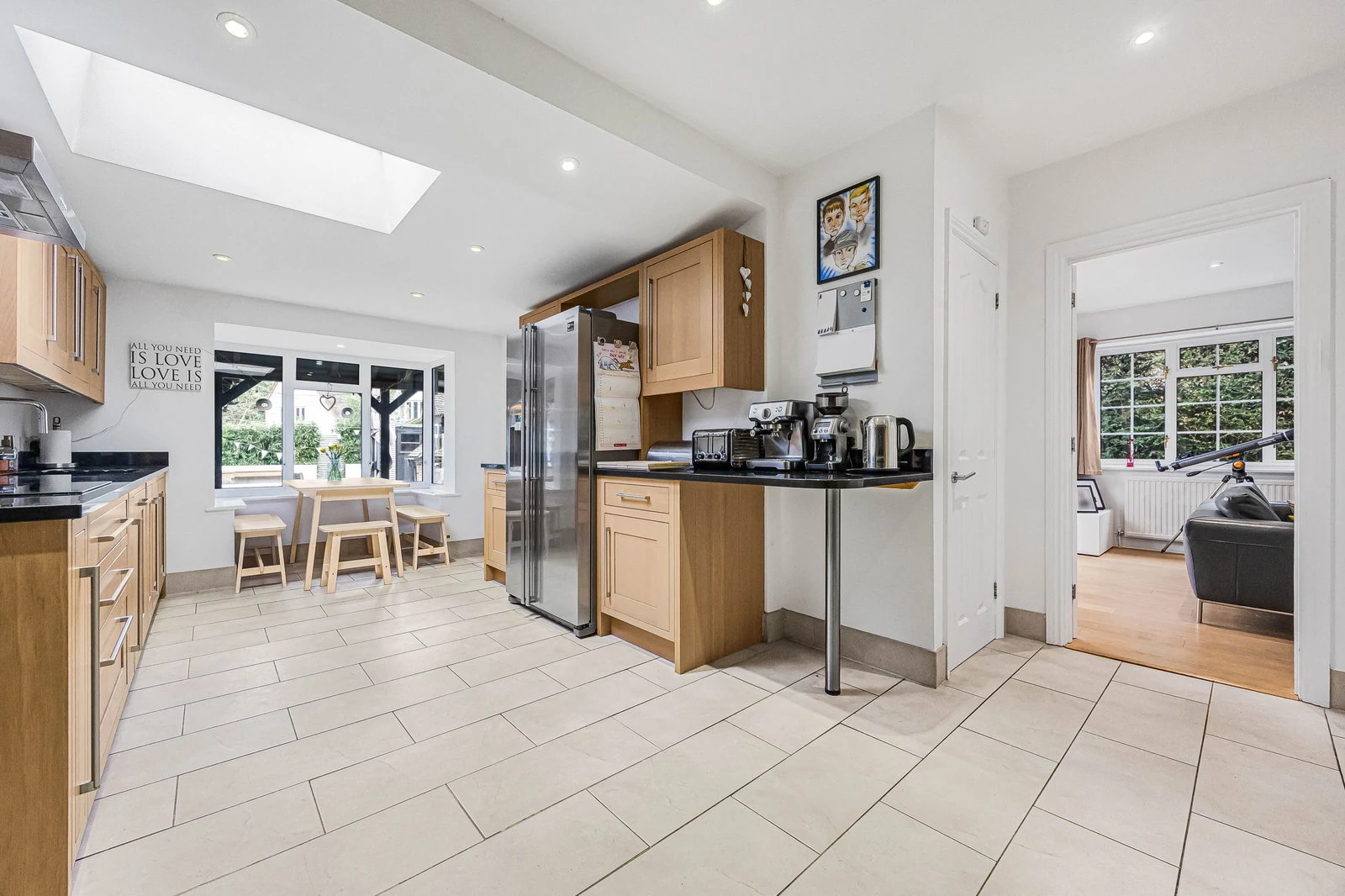 The kitchen at Fernie Cottage — deep blue island cabinetry, pendant lights, and doors to the garden