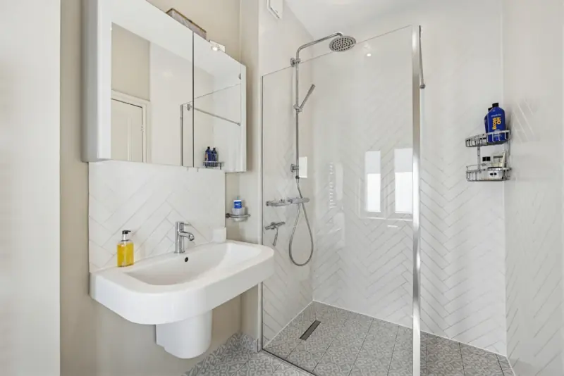 A walk-in shower bathroom with brushed-brass fittings