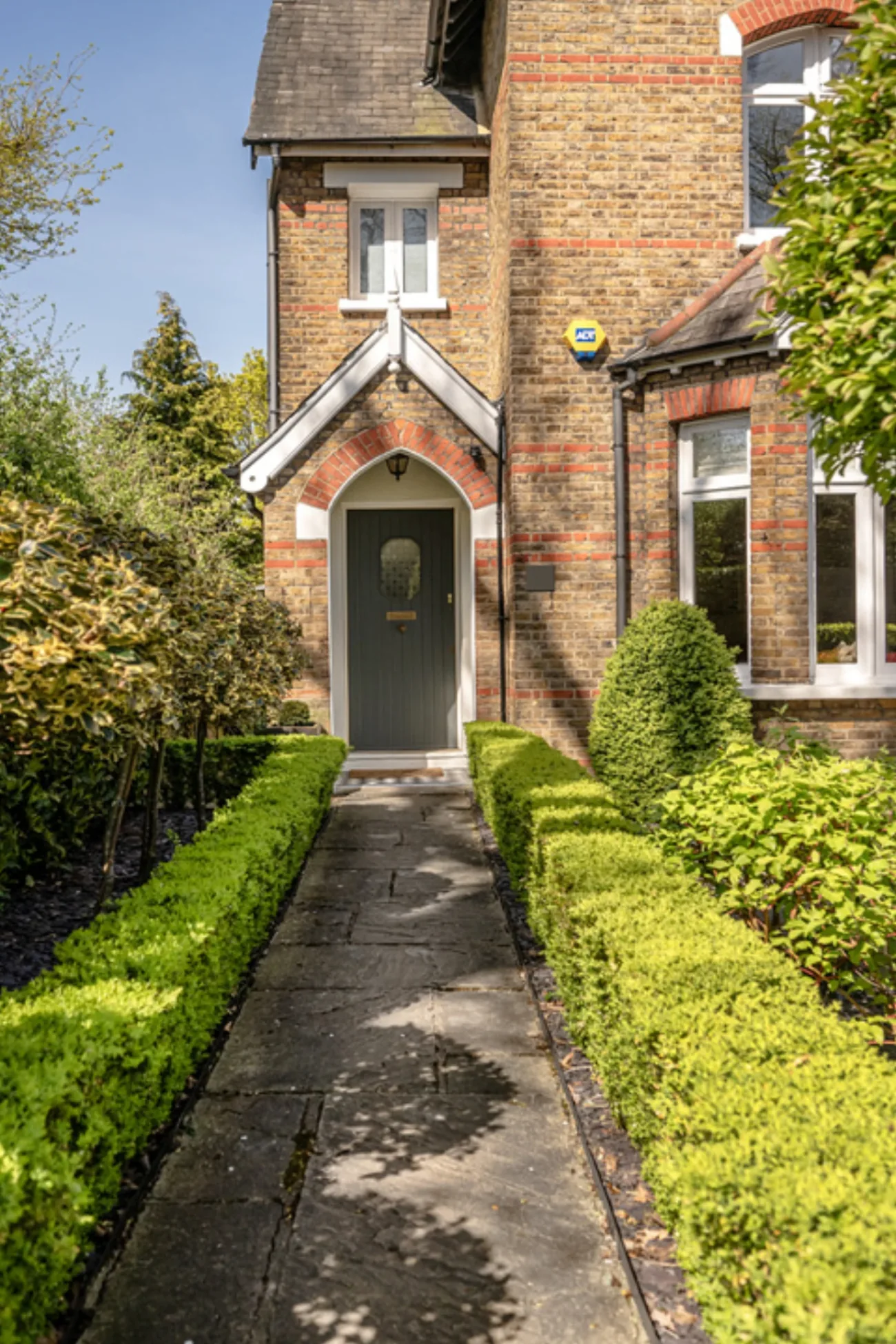 The principal entrance, framed by clipped hedging and the front garden