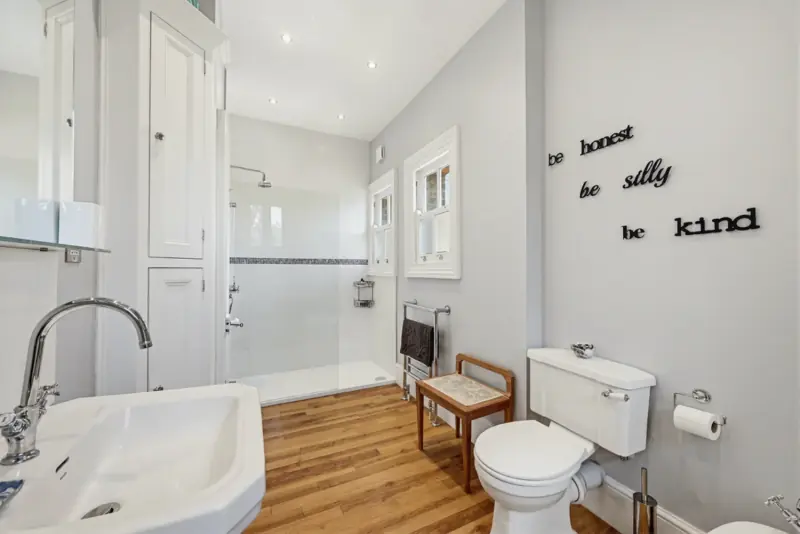 A vanity-and-toilet bathroom in pale stone tile