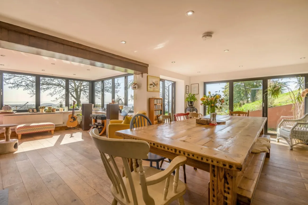 The dining-room conservatory at Little Caerlicken, bi-fold doors open to the garden