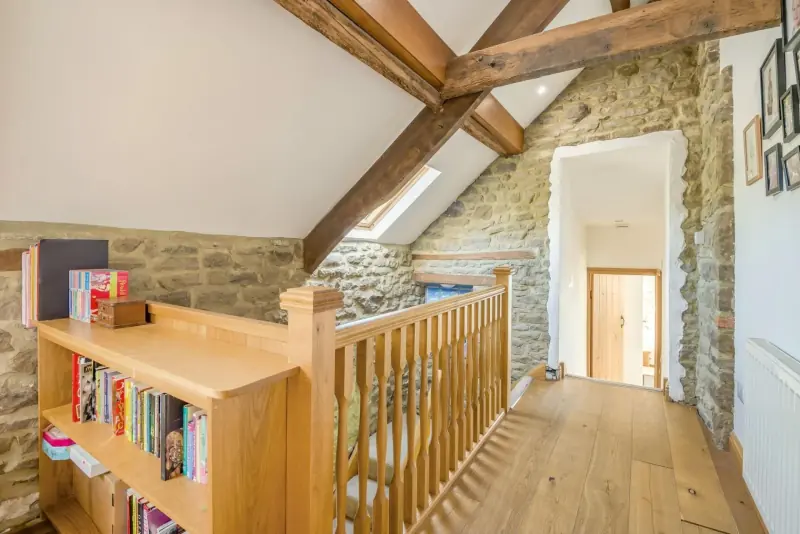 Book-lined landing with beams