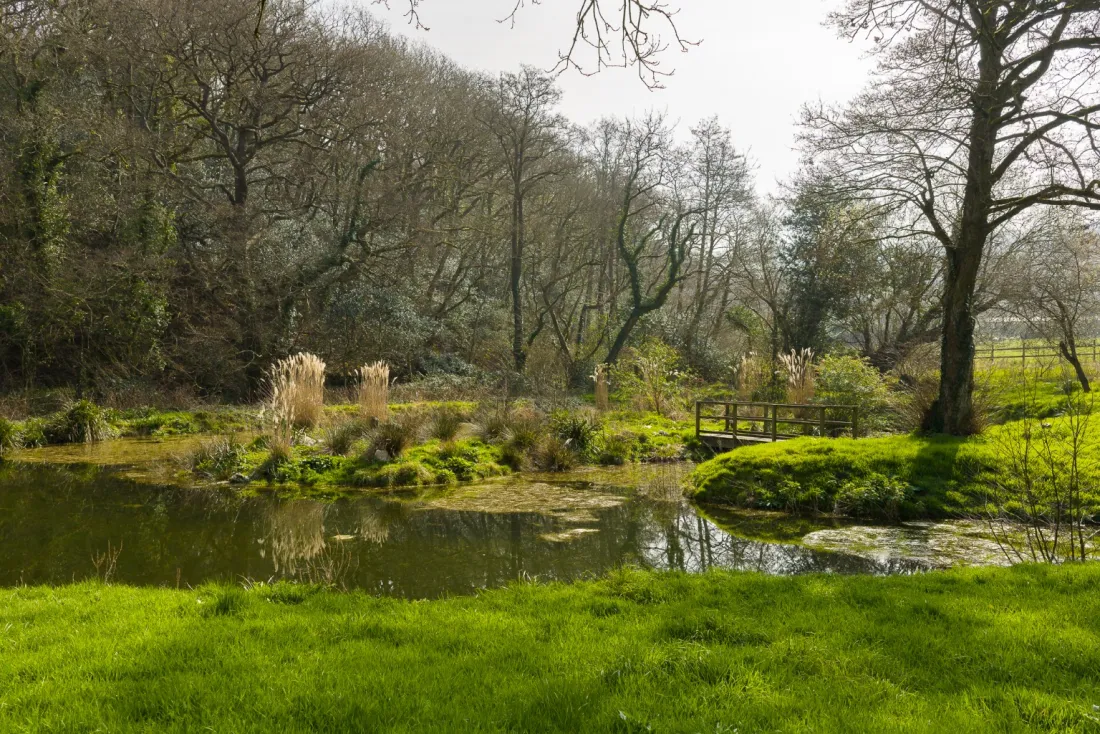 Spring-fed lake with stone barn beyond