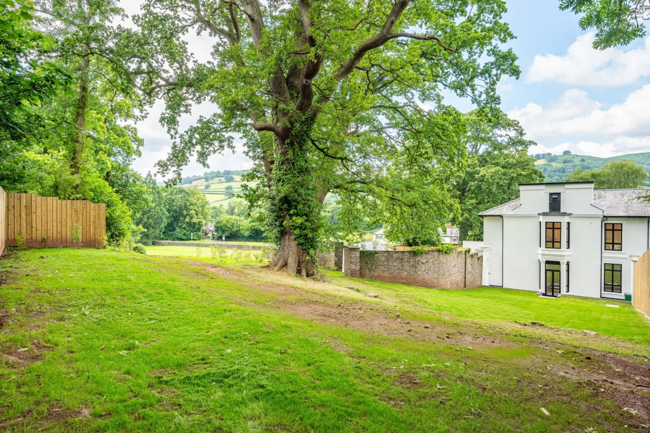 The level grounds framed by a mature tree