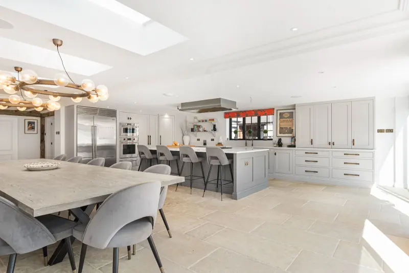 The black-stone kitchen with bar stools at the island