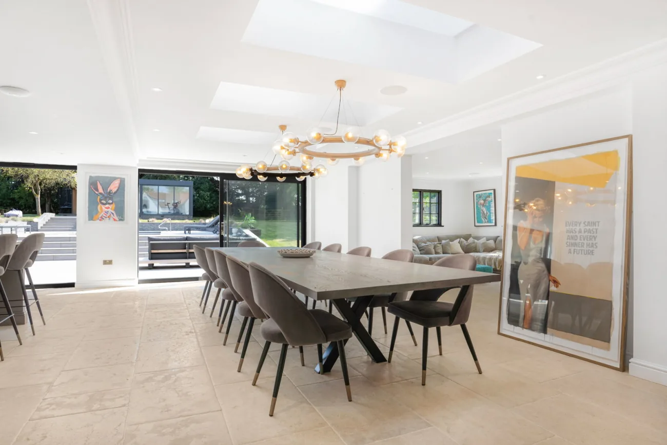 The dining table beneath a single chandelier