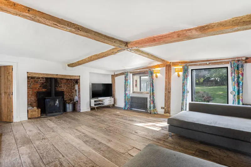 An open-plan view across the kitchen beneath beamed ceilings