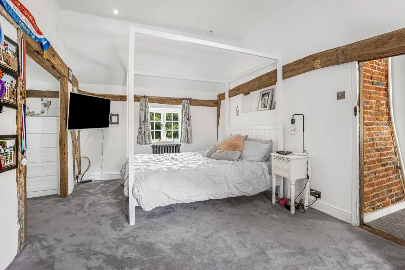 A double bedroom with vaulted ceiling and beamed ceiling