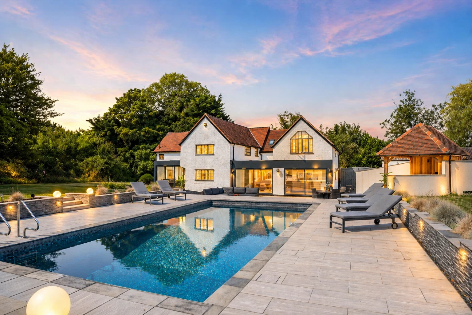 Sparrows Farm at golden hour, with the heated pool in the foreground and the rendered home behind