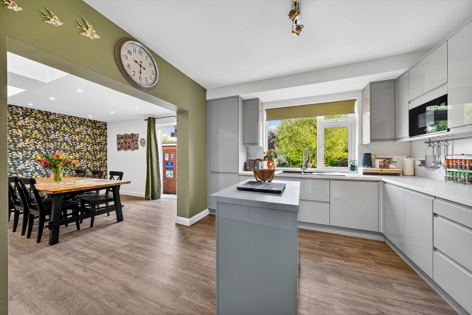 The open-plan kitchen-dining with central island and lantern roof lights