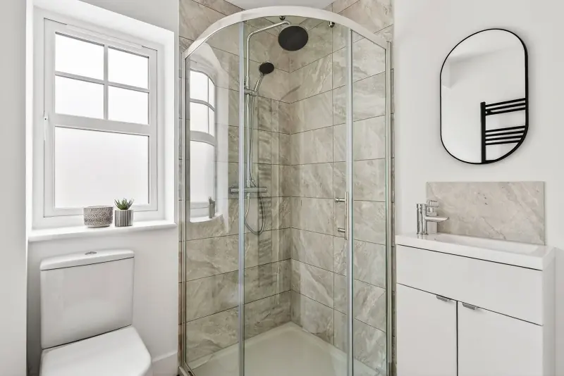 A shower room with arched window and gray marble