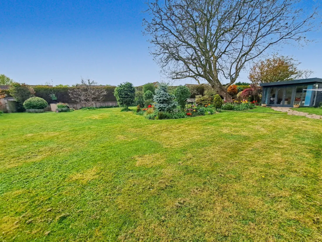 Mature, private gardens at Station Road, with the home and its curved facade beyond
