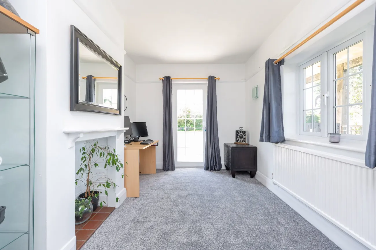 The study with French doors to the garden, marble fireplace surround, and a long working aspect.