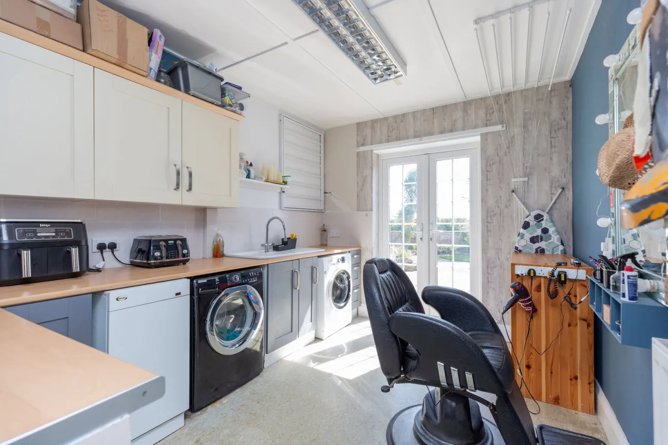 The utility room with washer, drier, sink, and a French-door garden link.