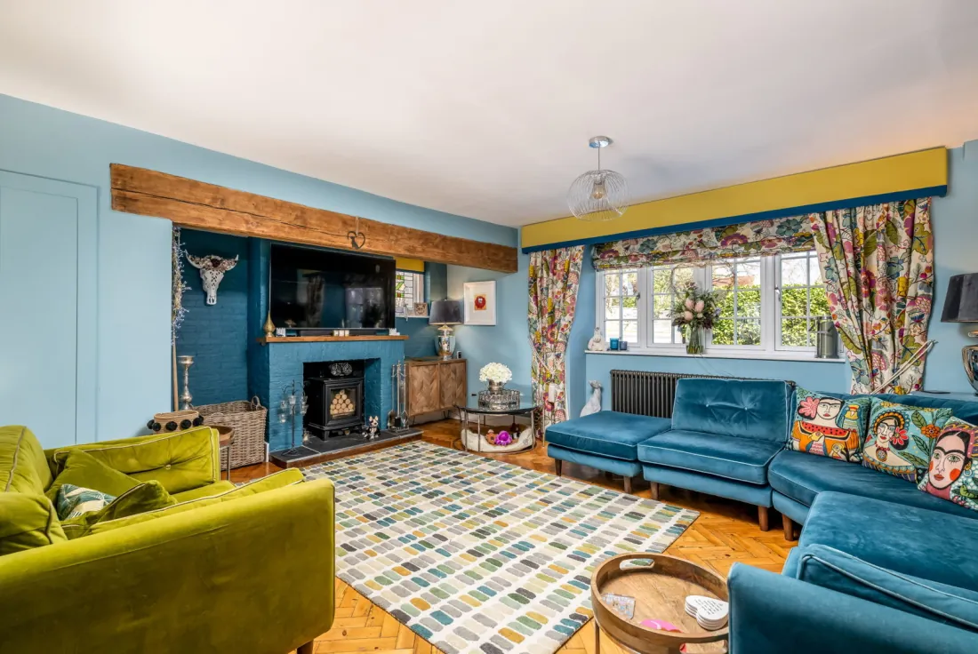 Inglenook lounge with herringbone flooring and log burner