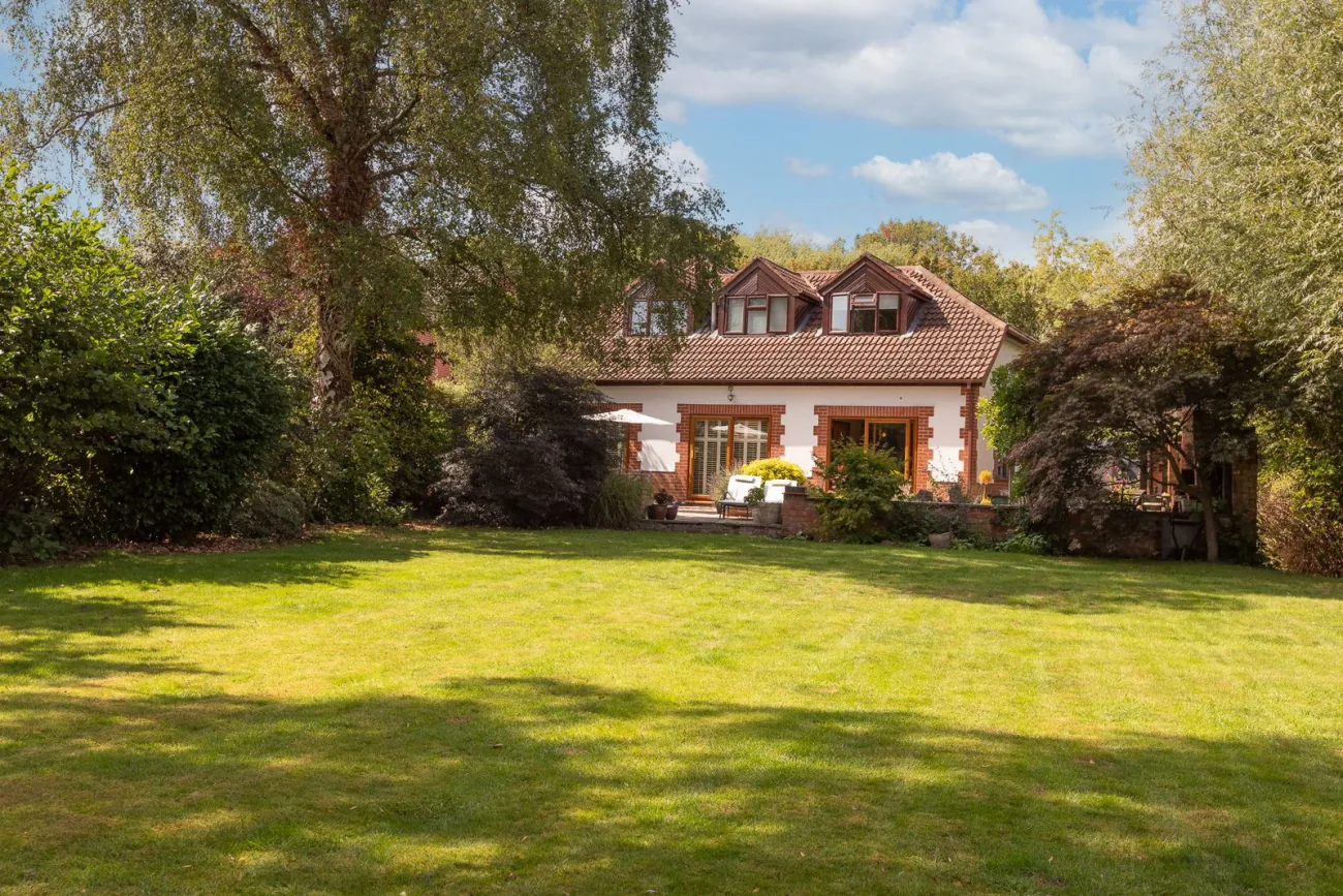 The garden looking back at the house — mature lawn and planting